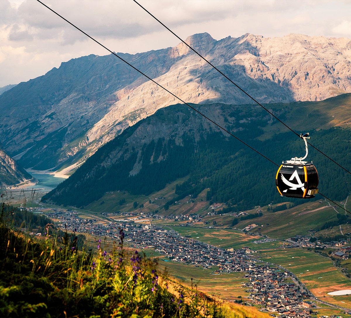 Cabinovia di Carosello 3000 in funzione con Livigno al Tramonto sullo Sfondo